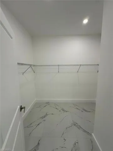 Walk in closet with light marble finish floors