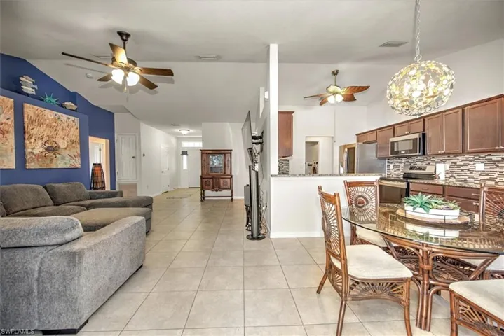 Open spacious concept floor plan with high vaulted ceilings, and tile floors.