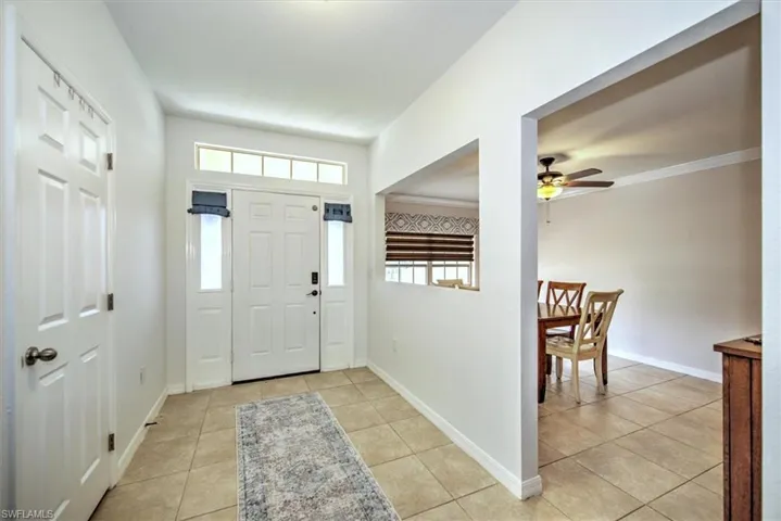 Entryway / foyer featuring light tile floors, ceiling fan, crown molding, and baseboards connecting to dining room (or den/office and / or 5th bedroom)...lots of options depending on your needs.