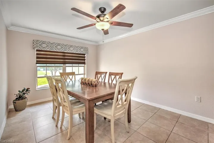 Dining room (or den/office and / or 5th bedroom) with ceiling fan, baseboards, crown molding, and tile flooring.