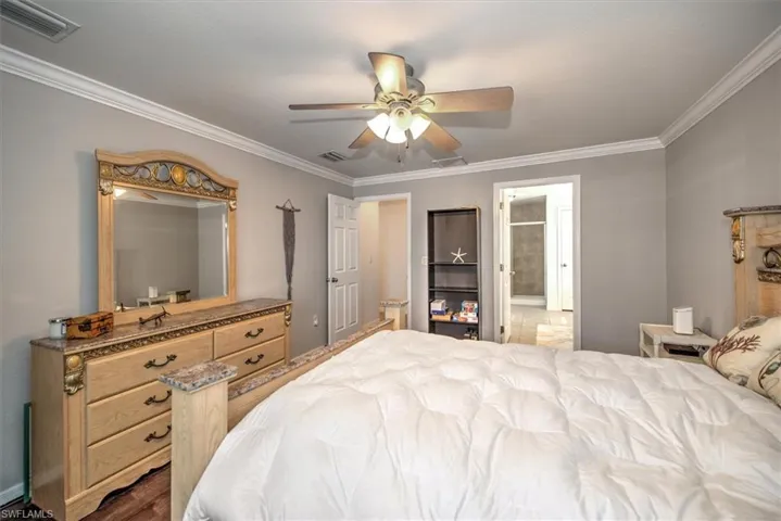 Additional view of primary bedroom featuring crown molding,  and connecting primary bathroom.
