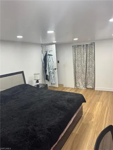 Room featuring wood-finish flooring, recessed ceiling lighting, and light-toned walls