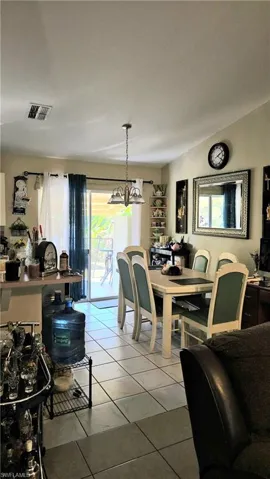 Dining area featuring a notable chandelier, light tile patterned floors, and visible vents