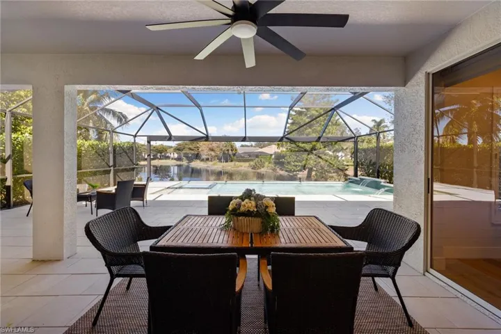 View of patio with an outdoor pool, a sunroom, a ceiling fan, and glass enclosure