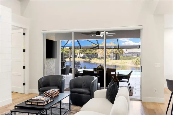 Living area with a sunroom, light wood finished floors, and ceiling fan