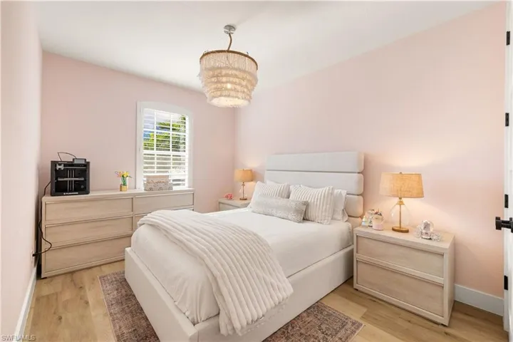 Bedroom with light wood-style flooring and a chandelier