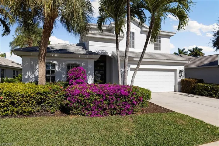 View of front of house with stucco siding, a garage, concrete driveway, a front lawn, and a tile roof