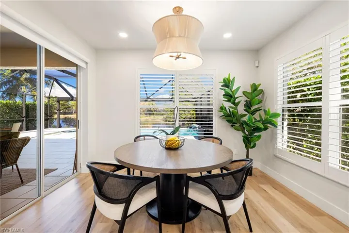 Dining room featuring light wood-style floors, a sunroom, and recessed lighting