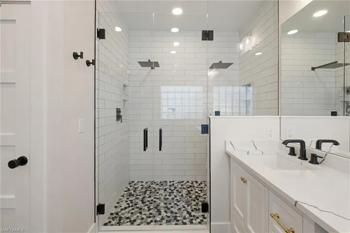 Bathroom featuring vanity, a shower stall, and recessed lighting