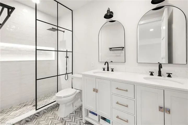 Full bathroom with a walk in shower, double vanity, and recessed lighting