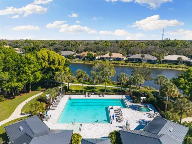Community pool with a patio, a residential view, a water view, and view of wooded area