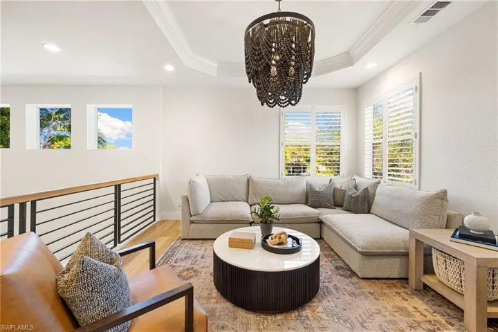 Living area featuring a chandelier, recessed lighting, ornamental molding, and wood finished floors
