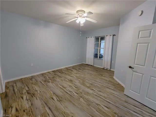 Empty room with light hardwood / wood-style flooring and ceiling fan