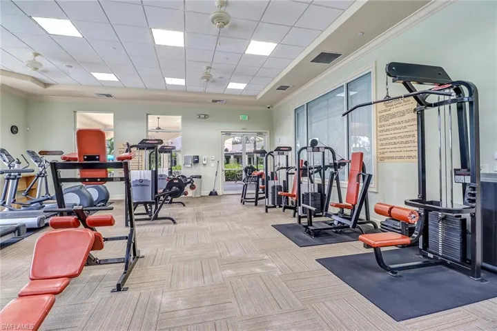 Exercise room with crown molding and a drop ceiling