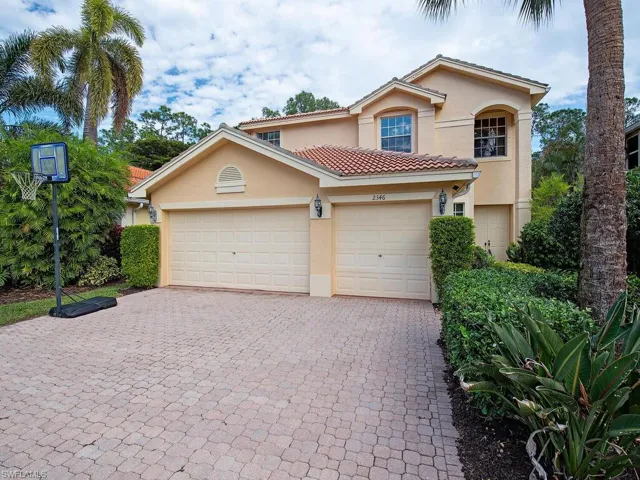 Mediterranean / spanish-style house with stucco siding, decorative driveway, and a garage