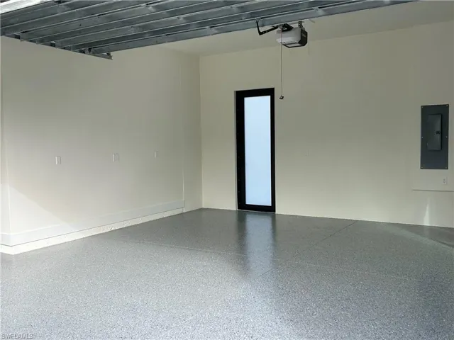 Garage with electric panel and a garage door opener