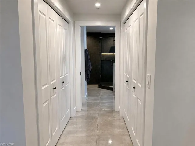 Hallway featuring light-toned tile flooring and recessed lighting