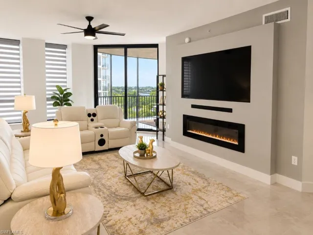 Living area featuring a built-in electric fireplace, wall-mounted television, and a black ceiling fan