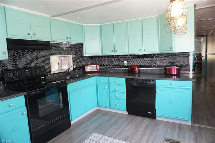 Fully equipped kitchen has wood cabinets with soft close doors
