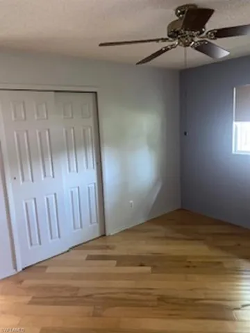 Bedroom # 2 with large closet and wood floors and a ceiling fan.