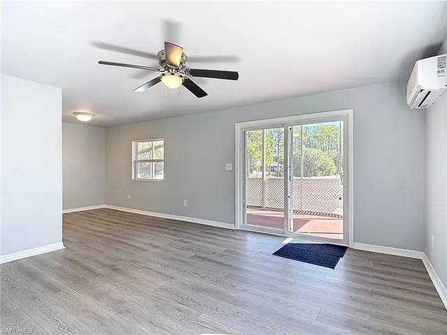 Entryway with ceiling fan, a mini split for heating / cooling, and wood finished floors