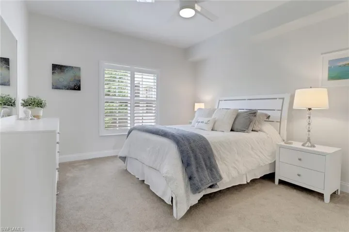 Bedroom with light colored carpet and ceiling fan
