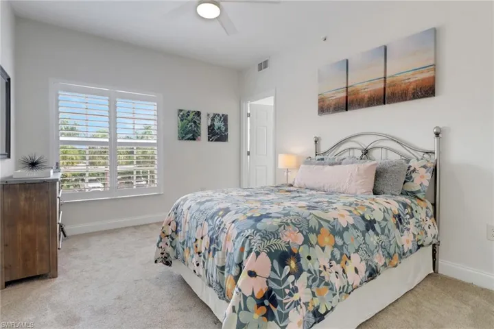 Bedroom with light colored carpet and ceiling fan