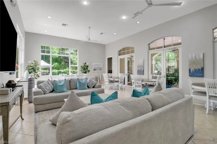 Living area with light tile patterned floors, recessed lighting, ceiling fan, and french doors