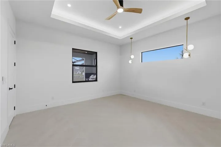 Empty room featuring a tray ceiling, recessed lighting, and a ceiling fan