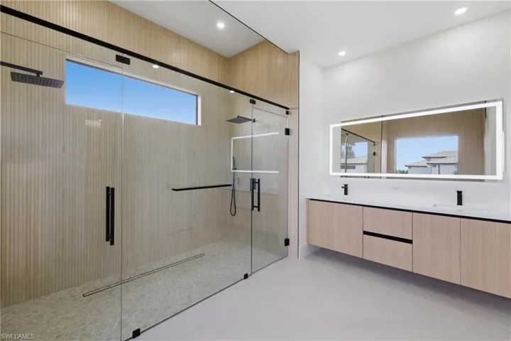 Full bathroom with double vanity and a shower stall
