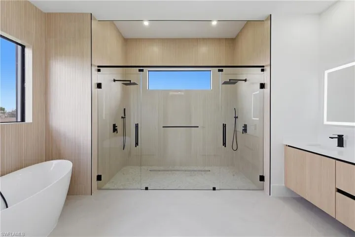 Bathroom featuring a shower stall, a soaking tub, vanity, and light tile patterned flooring