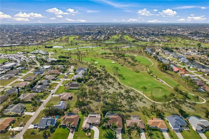 Aerial view of property's location with nearby suburban area and a local golf course