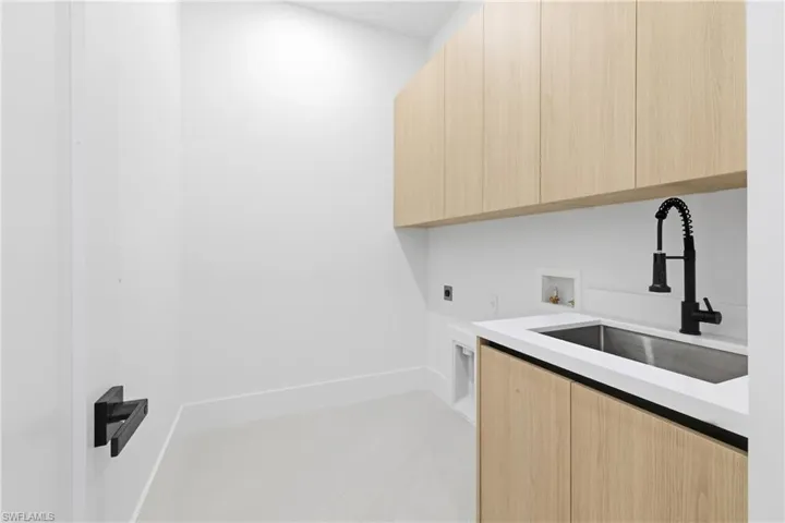 Laundry area featuring electric dryer hookup, washer hookup, and cabinet space