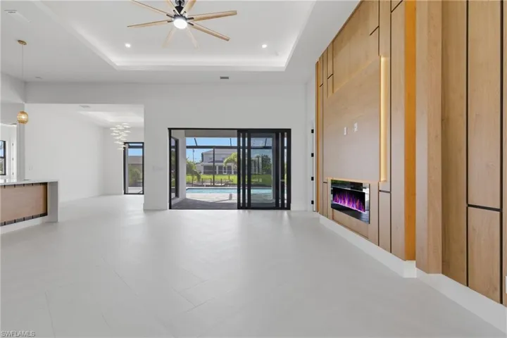 Unfurnished living room with a glass covered fireplace, a ceiling fan, and recessed lighting