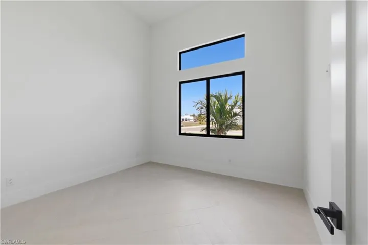 Spare room featuring a high ceiling and baseboards