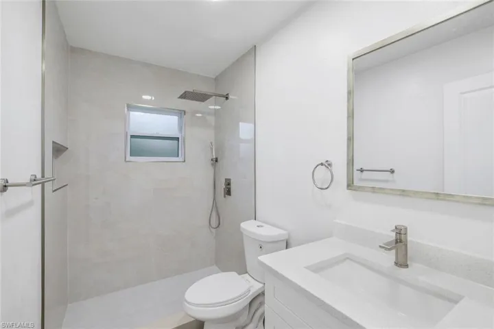 Bathroom with vanity and tiled shower