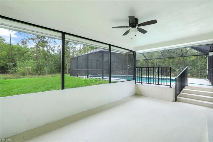 Unfurnished sunroom featuring ceiling fan and a patio area