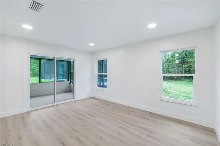 Unfurnished room with healthy amount of natural light, light wood-style flooring, and recessed lighting