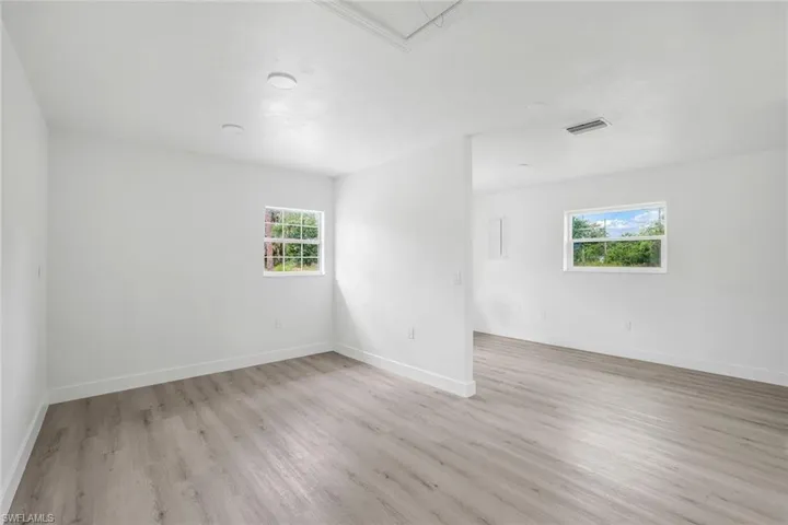 Spare room featuring light wood finished floors and attic access