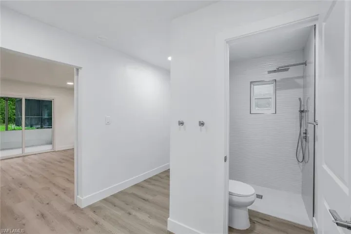 Bathroom featuring a walk in shower, light wood-style flooring, and recessed lighting