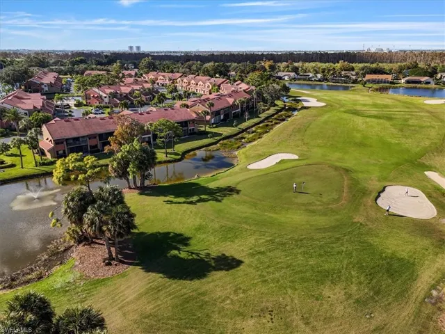 Aerial perspective of suburban area featuring a large body of water and a golf club