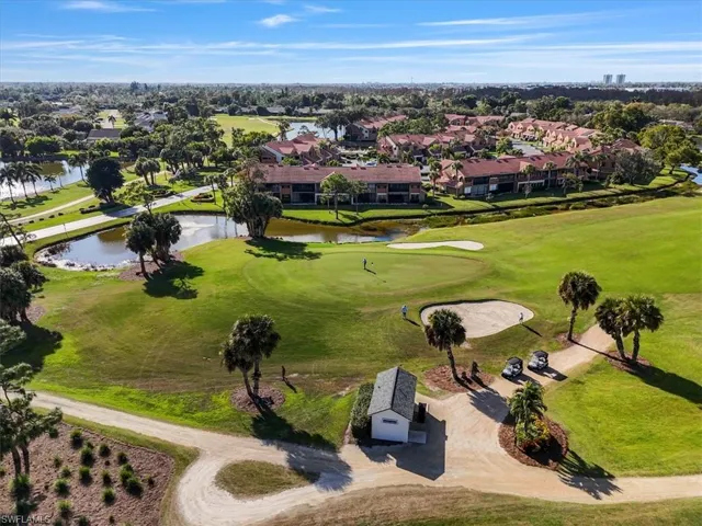 Aerial perspective of suburban area with a large body of water and a golf course
