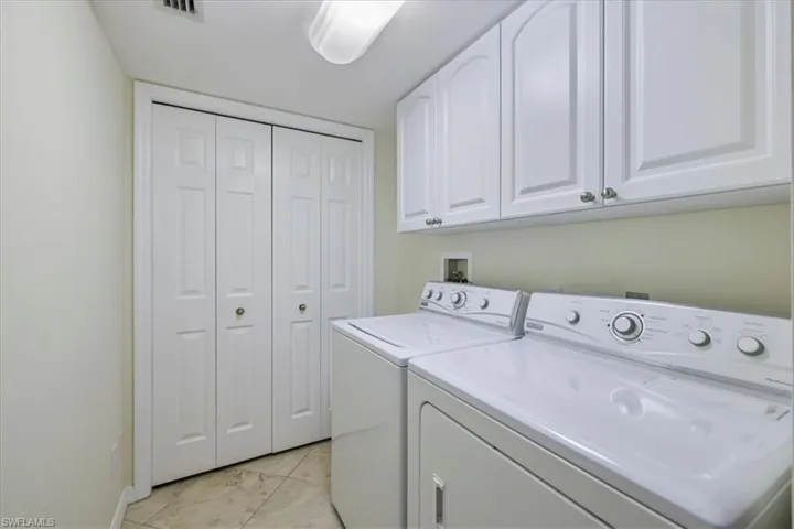 Washroom featuring washer and clothes dryer and cabinet space