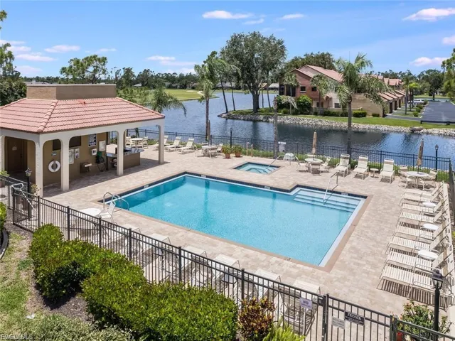 Community pool with a patio, a water view, and a hot tub