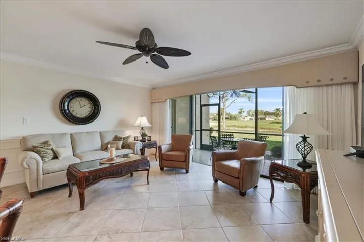 Living area featuring ornamental molding, a ceiling fan, and light tile patterned floors