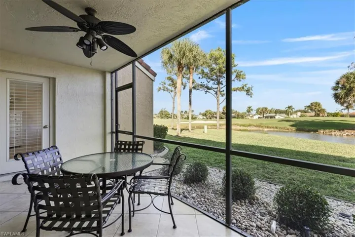 Sunroom with a water view, ceiling fan, view of golf course, and outdoor dining space
