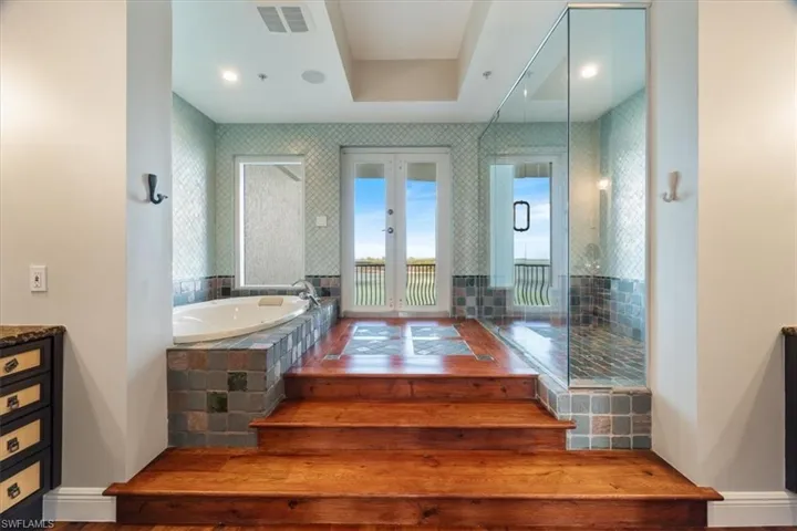 Owner's suite bath with shower, tub, and two vanities. Features outdoor balcony step-out