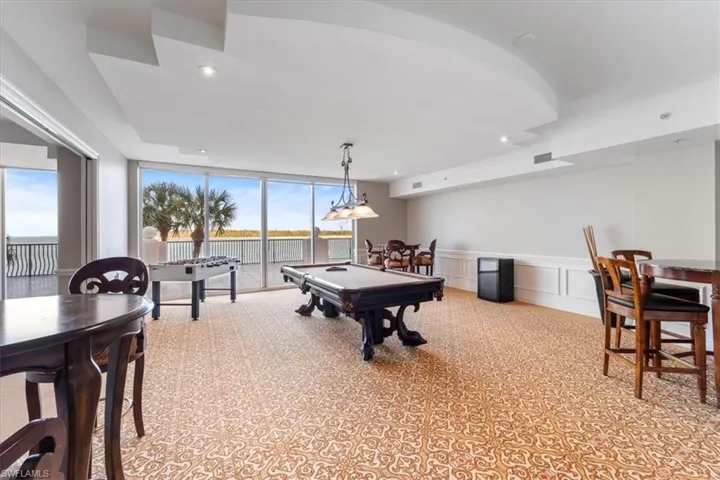 Game room with a wealth of natural light, expansive windows, and pool table.