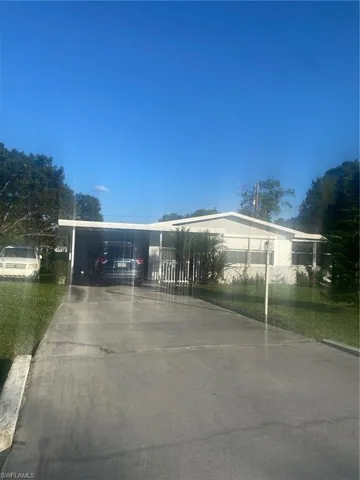 View of front of property featuring driveway and an attached carport