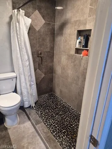 Bathroom with a shower stall and toilet